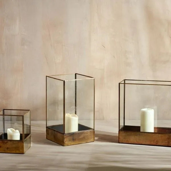Sampara storm lanterns in glass and antique brass with pillar candles