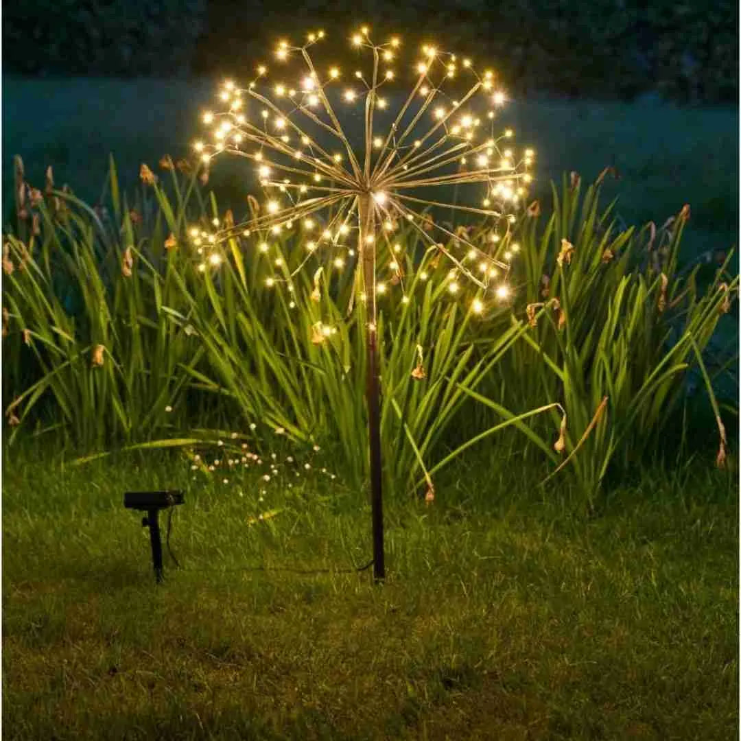 Close-up of a dandelion starburst solar light with its solar panel in grass