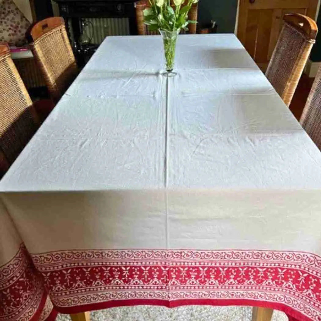Ruby Garland tablecloth with a deep red printed border on a long dining table