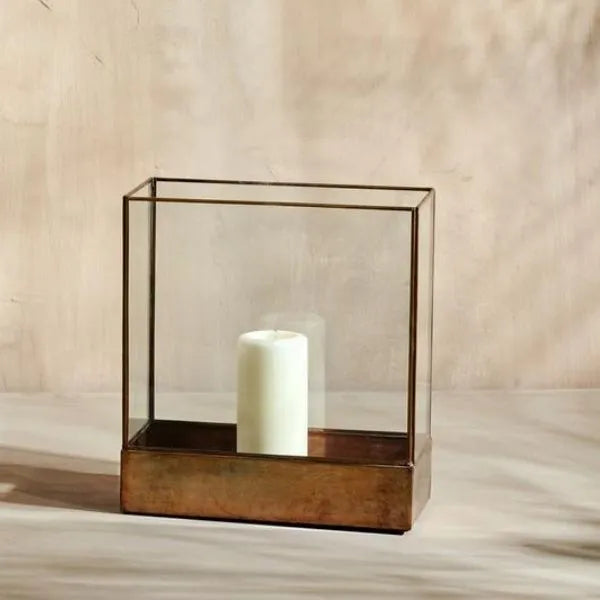 Sampara glass storm lantern holding a white pillar candle
