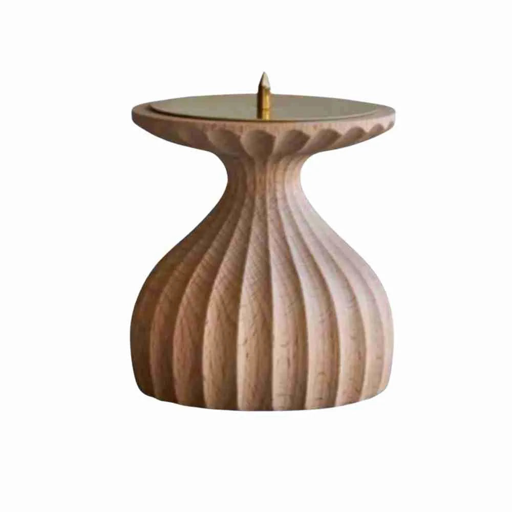 Ribbed wooden candle holder with a brass candle spike, on a white background
