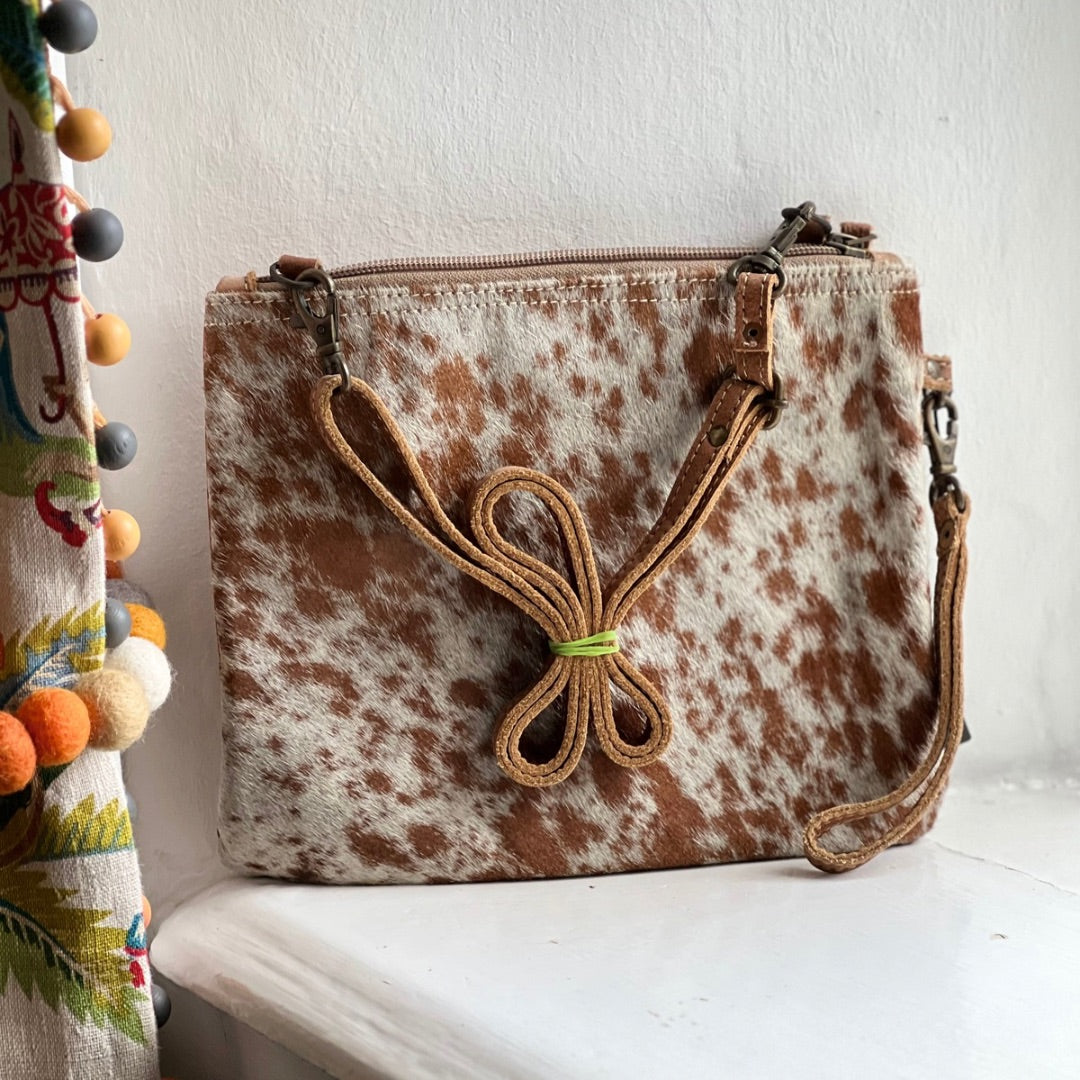 Square crossbody bag in brown and white cowhide with a knotted leather strap