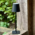 Black LED cordless table lamp on a garden table