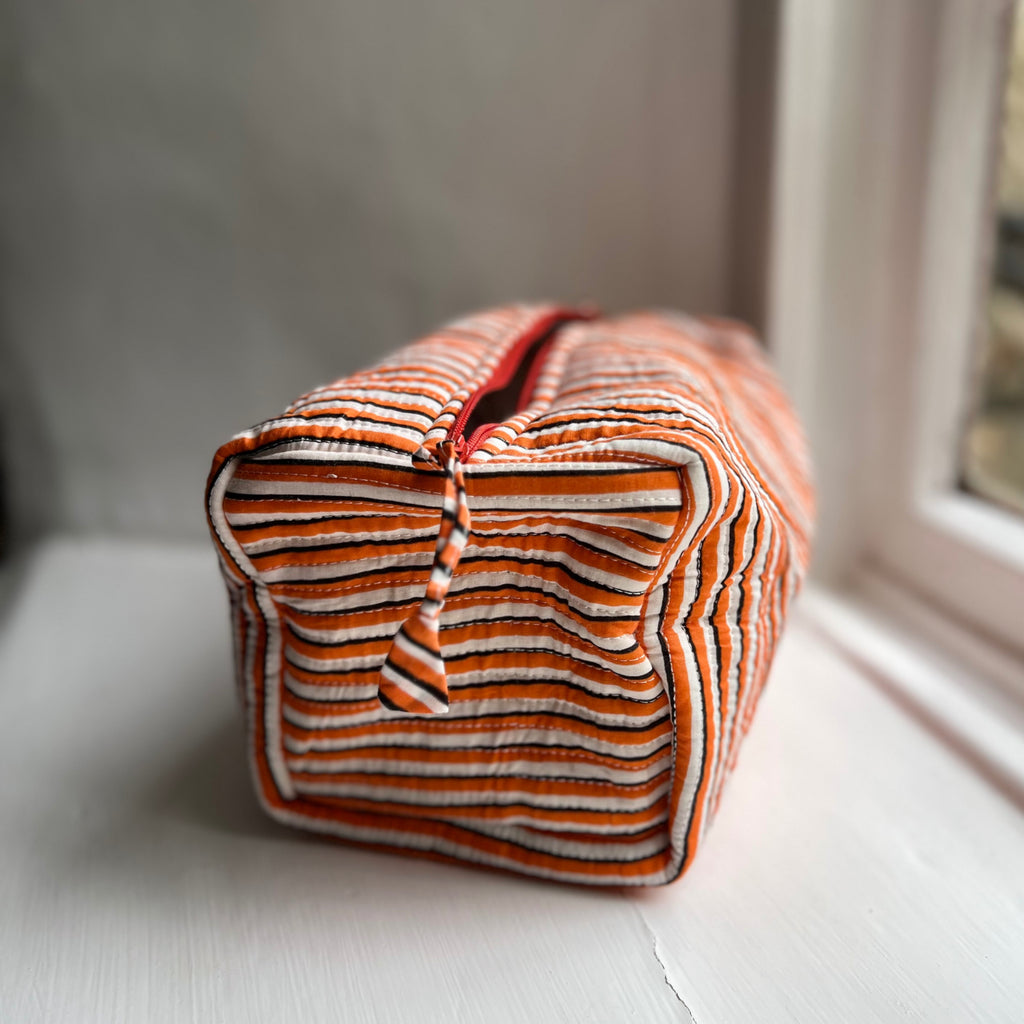 Harlequin quilted cotton washbag in orange stripe, side view