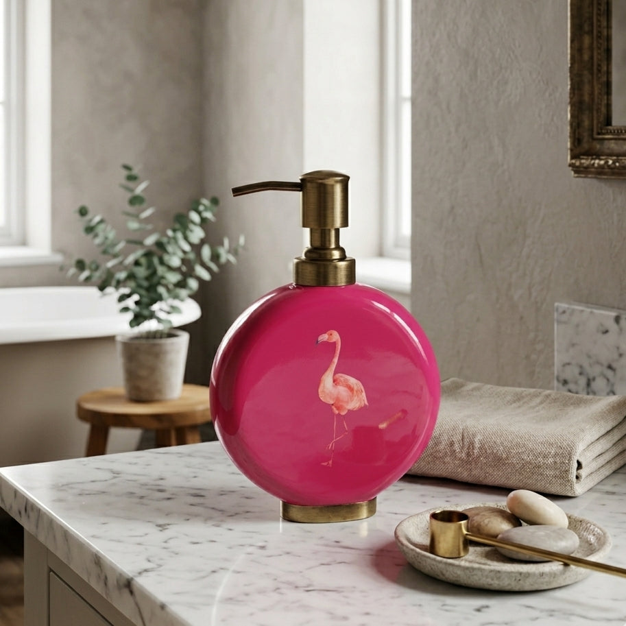 Flamingo enamel and brass soap dispenser in raspberry pink on a shelf