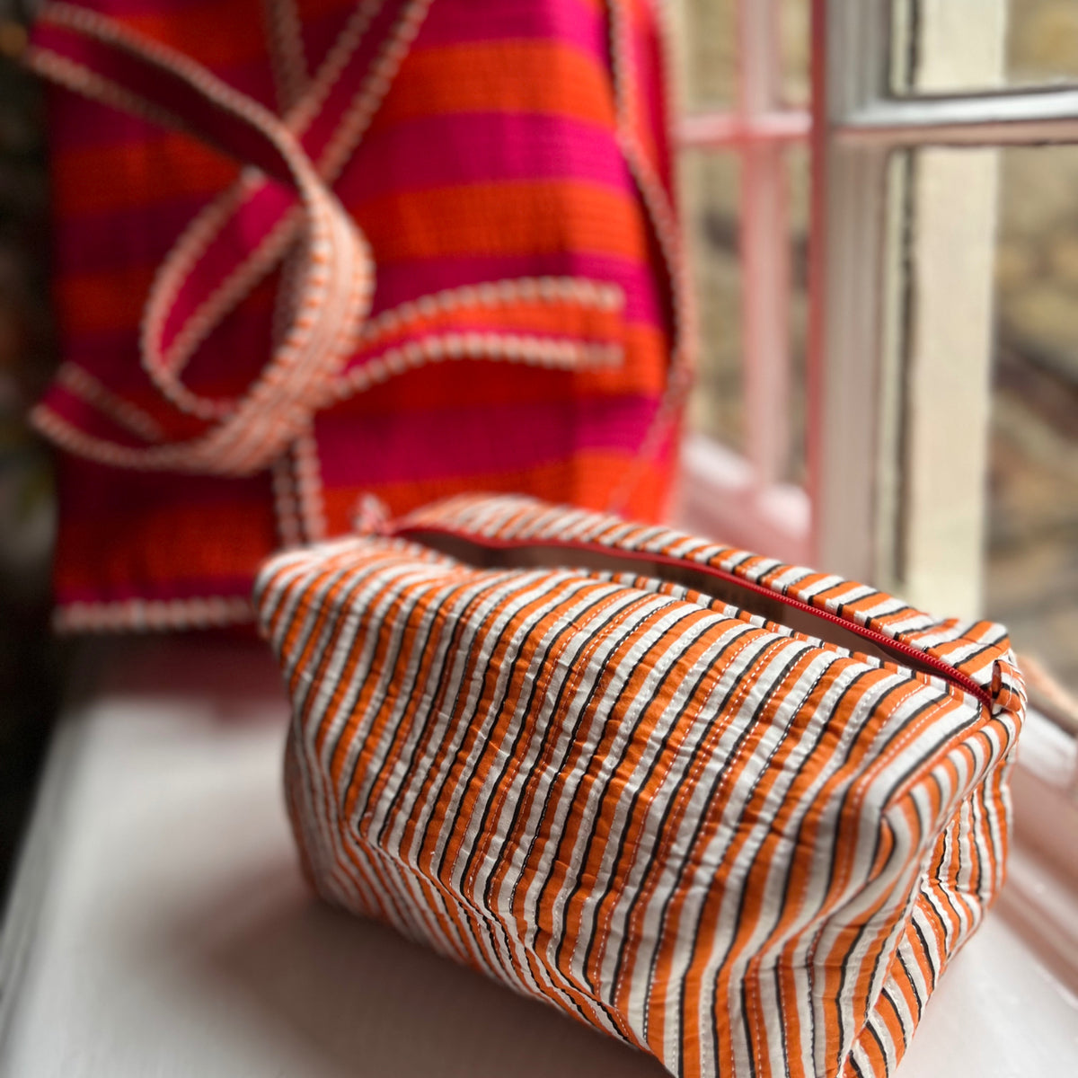 Orange and pink weekend bag with a matching washbag
