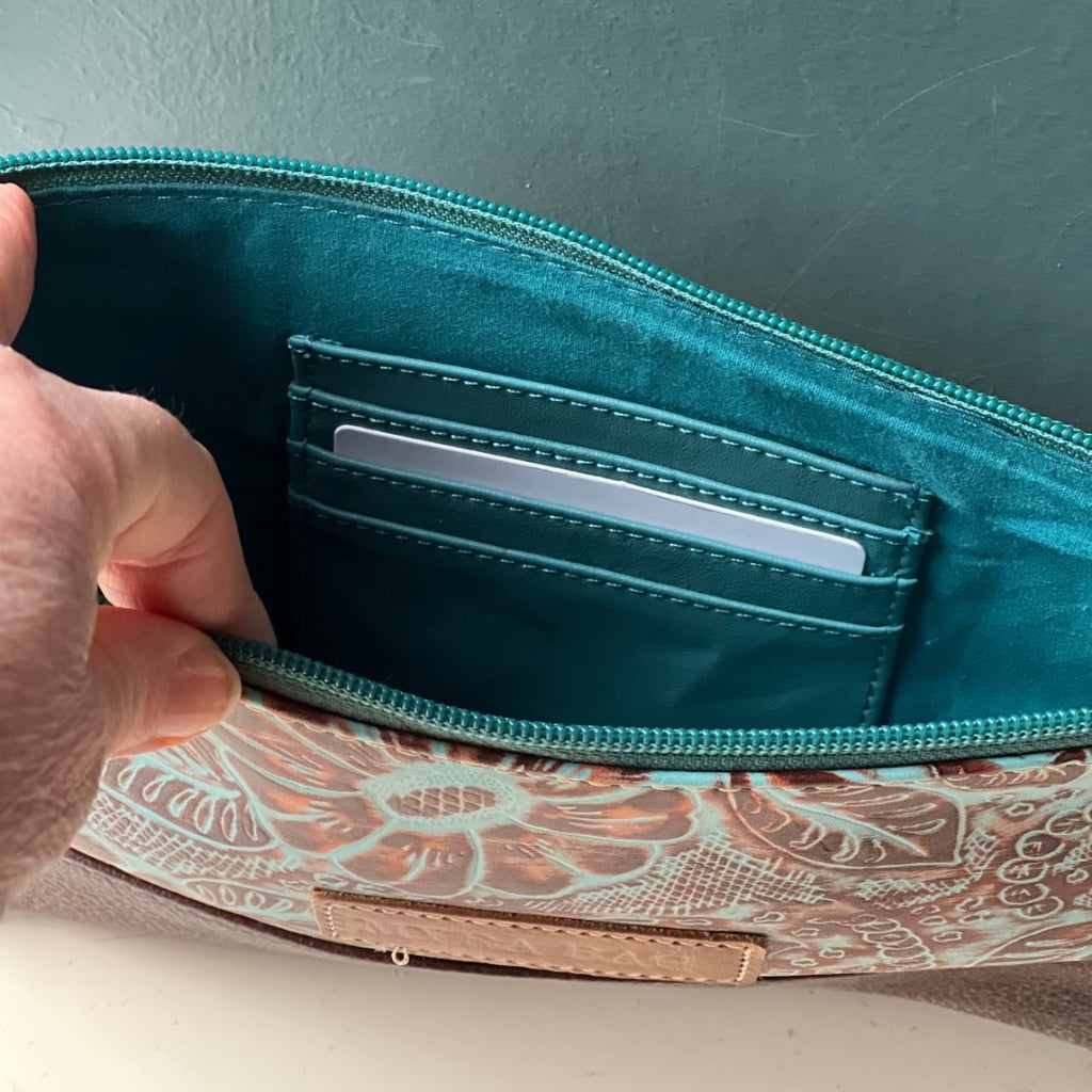 Inside the turquoise leather clutch bag, showing card slots and teal lining
