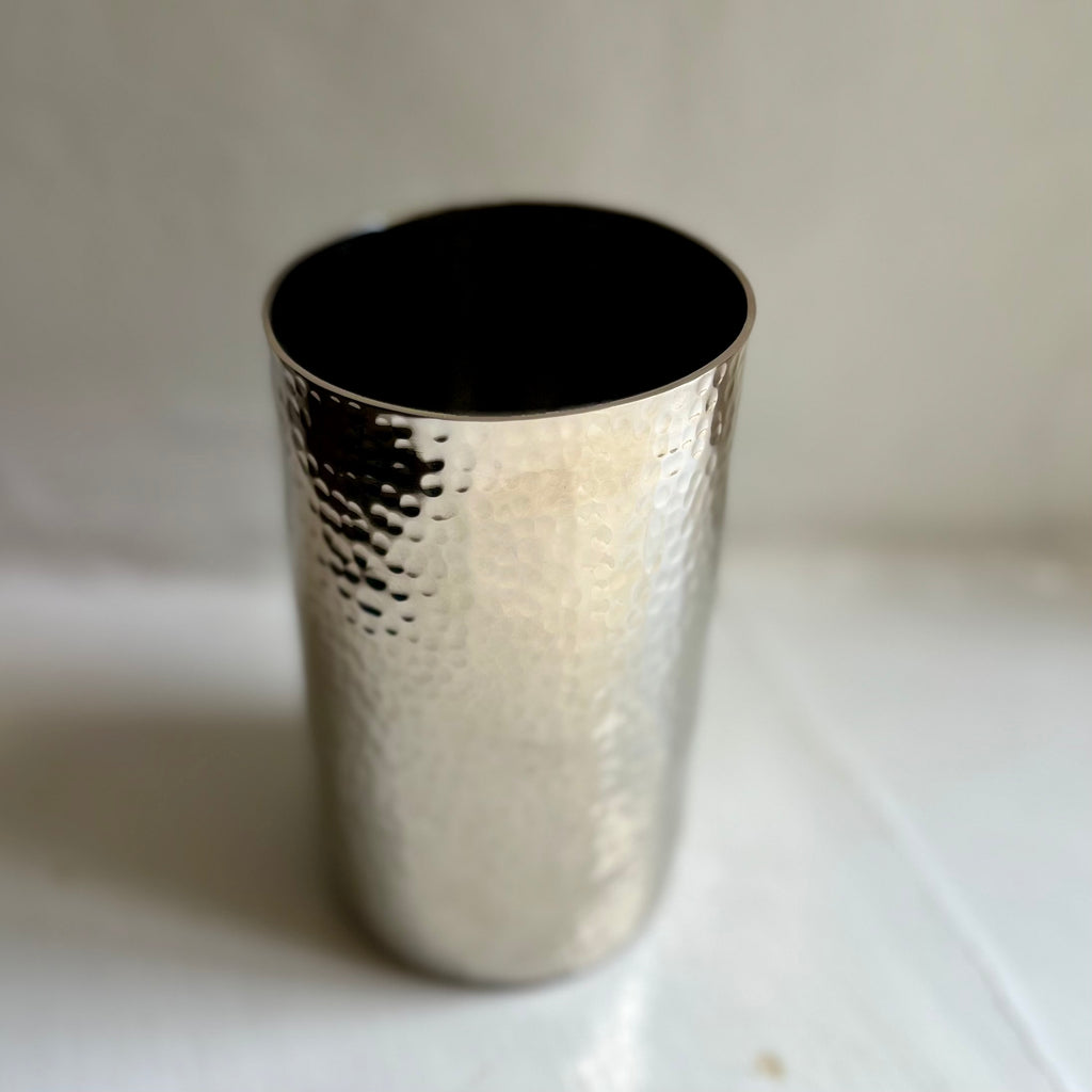 Handmade hammered metal tumbler in silver, close-up of the hammered finish