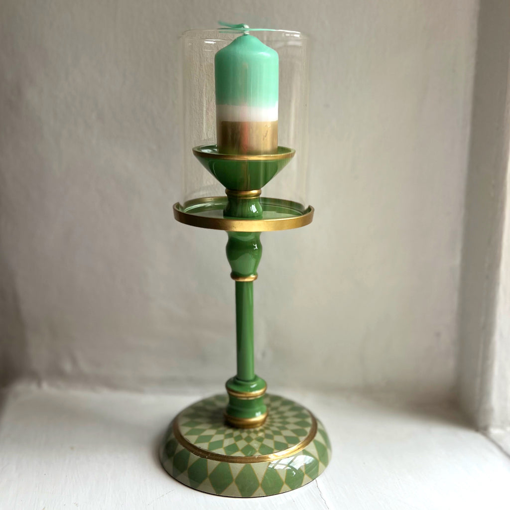 Small gold dipped pillar candle in sage green, shown in a green enamel candlestick