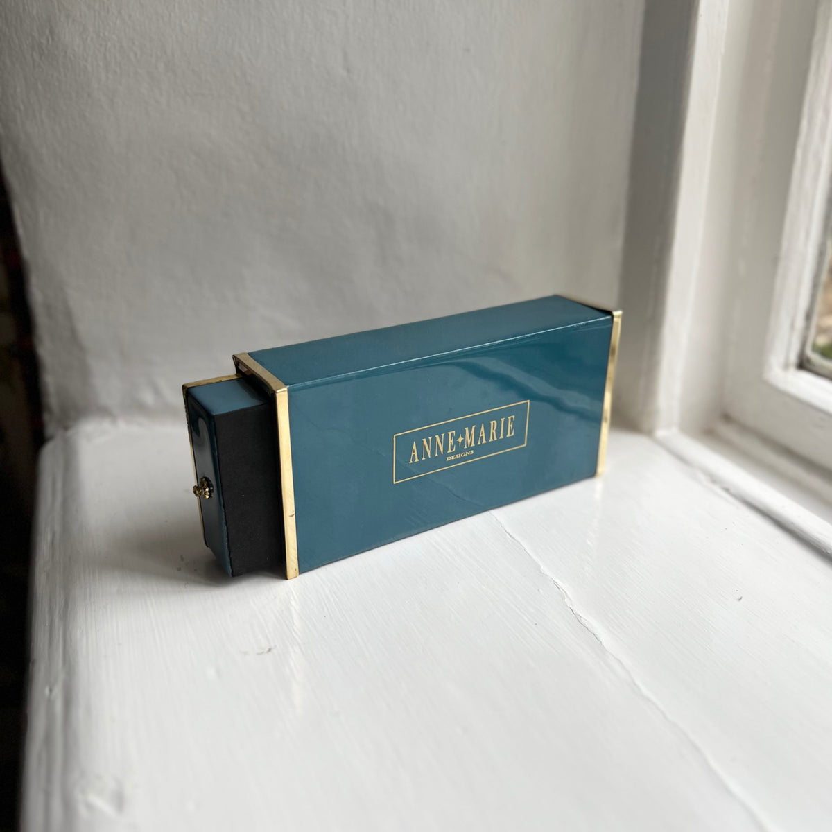 Butterfly oversized matchbox in teal enamel and brass showing the striker side