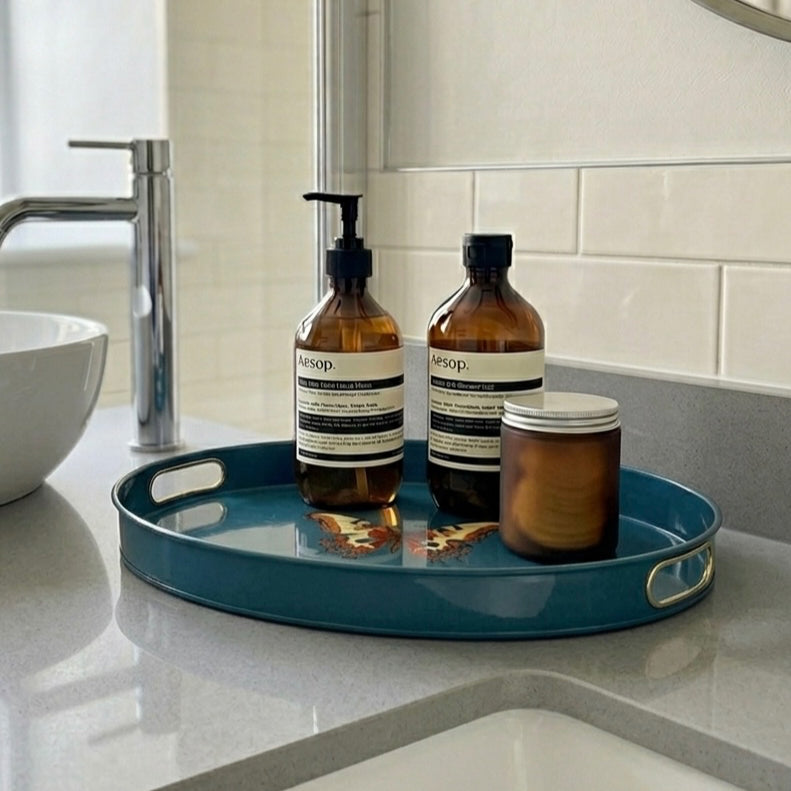 Butterfly large oval tray in teal enamel and brass with bottles in a bathroom