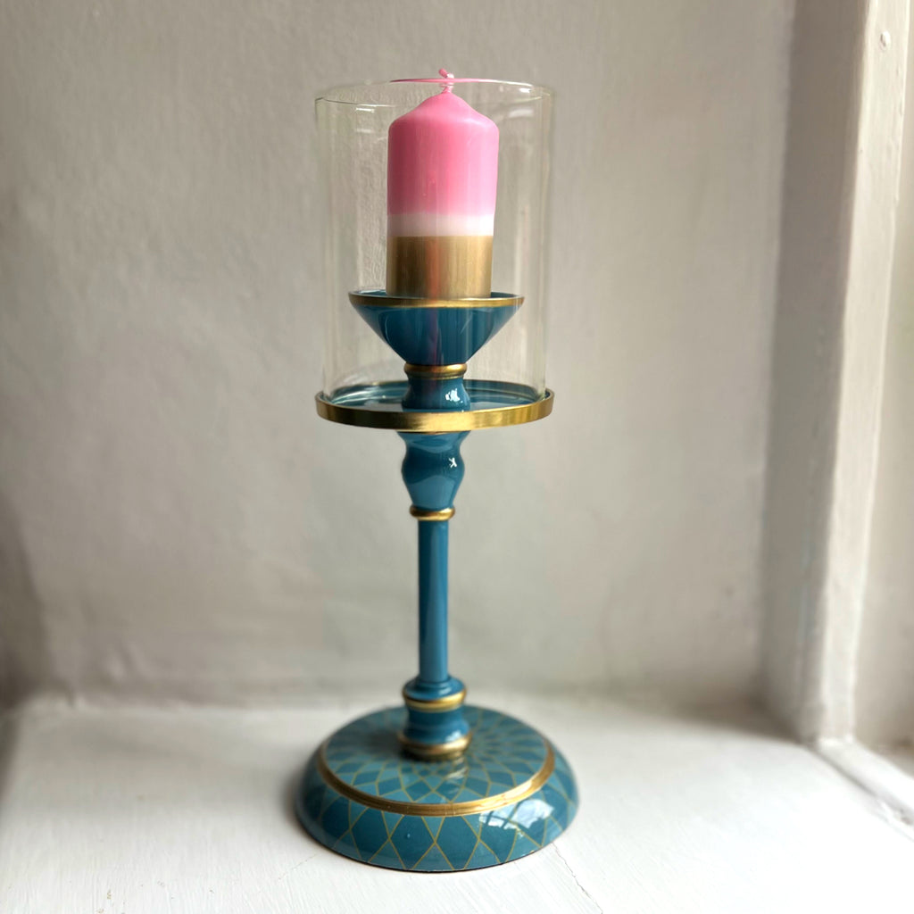 Harlequin hand-enamelled brass hurricane candle holder in Denim Blue with a pink pillar candle
