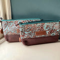 Two turquoise and brown floral embossed leather clutch bags