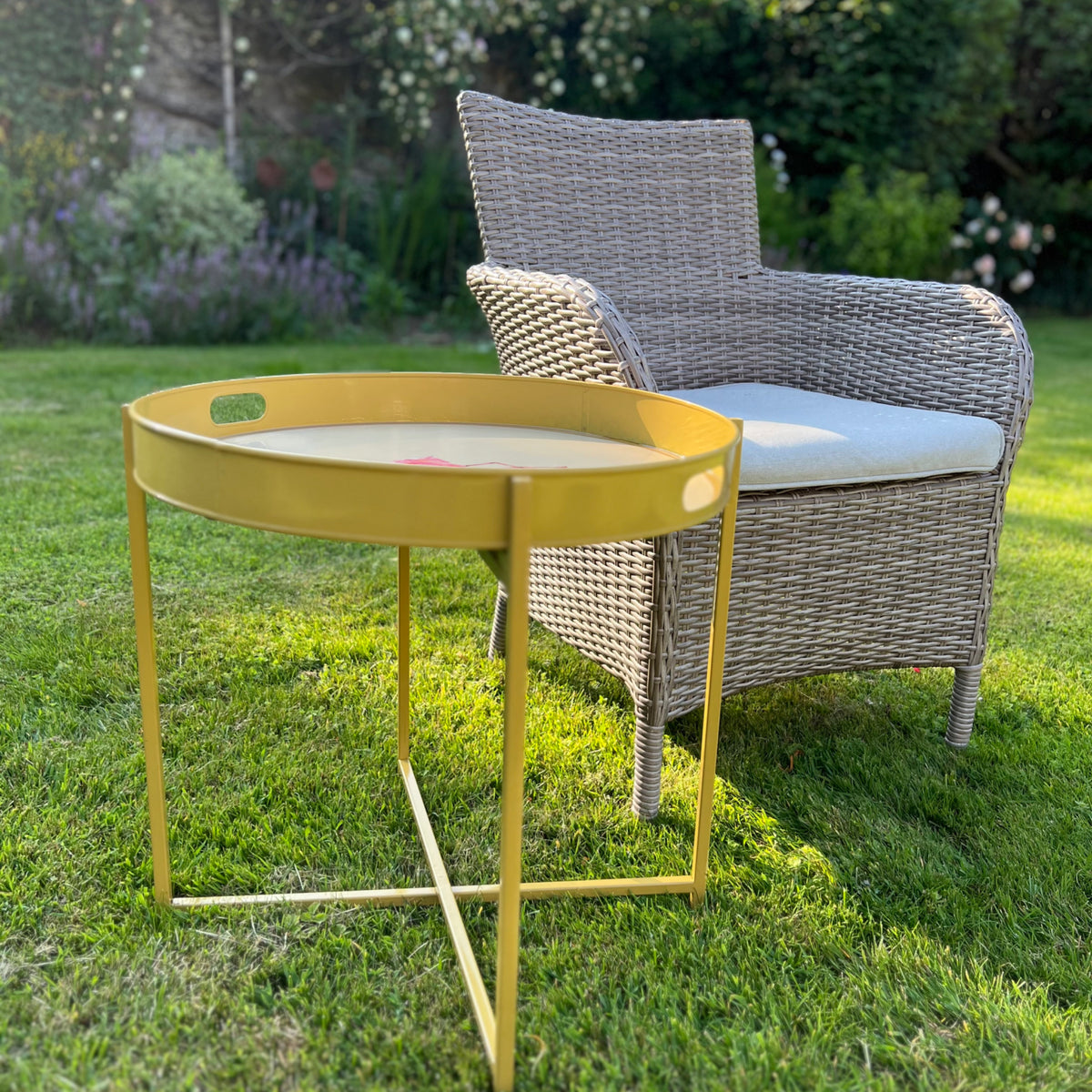 Gold folding tray stand with a round tray, on a garden lawn