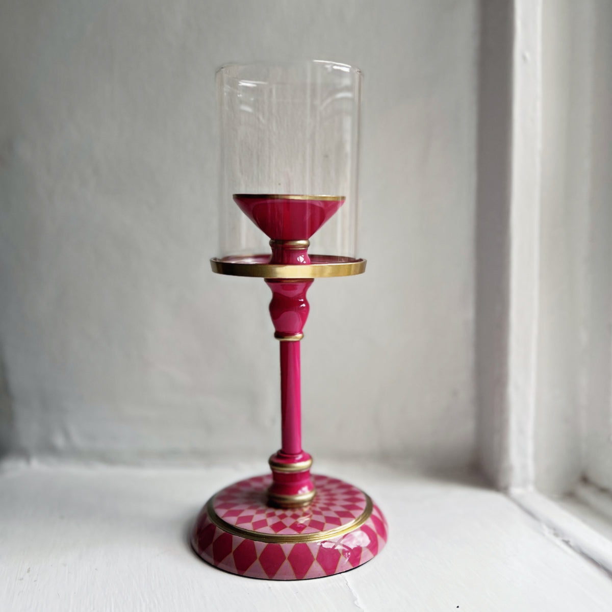 Harlequin hand-enamelled brass hurricane candle holder in Raspberry Pink with a glass sleeve