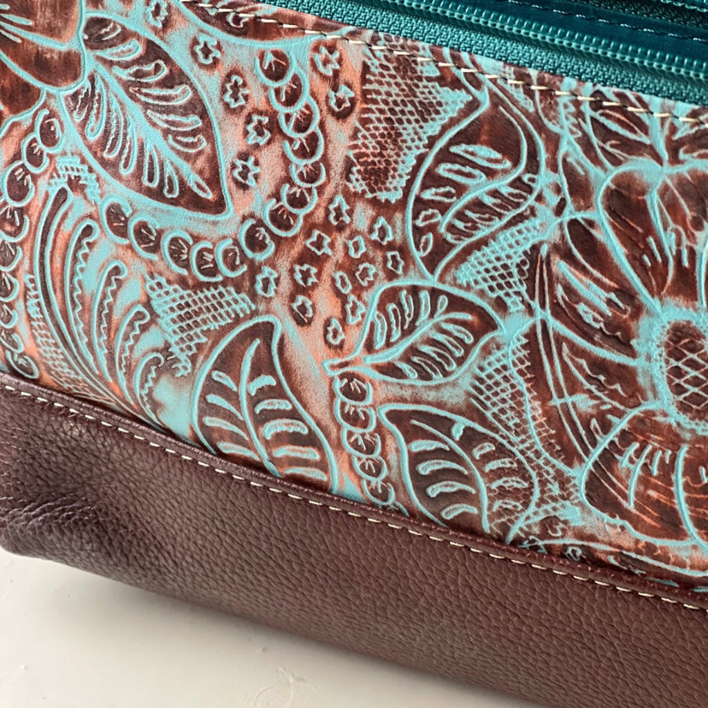 Close-up of the turquoise floral embossed leather and brown leather base
