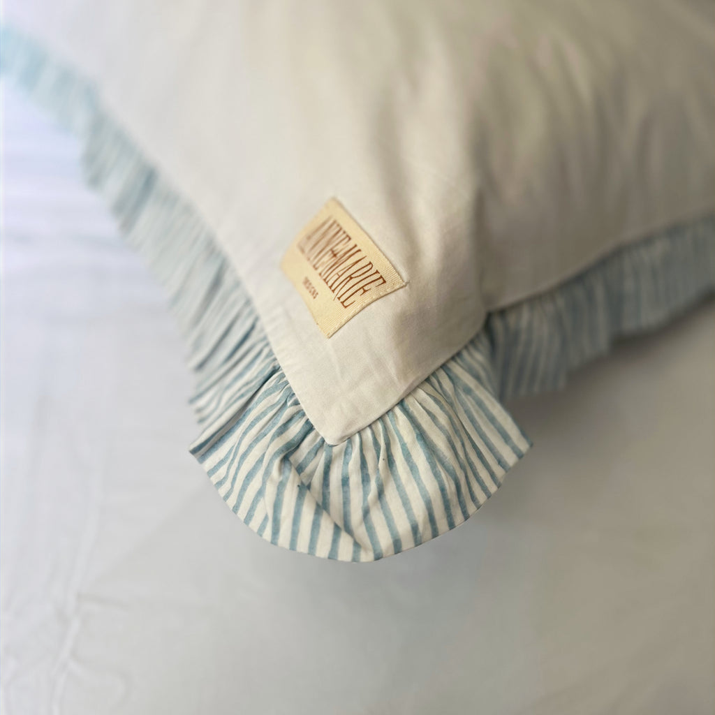 Corner of a Sea Breeze Blue Harlequin pillowcase showing the label and frill