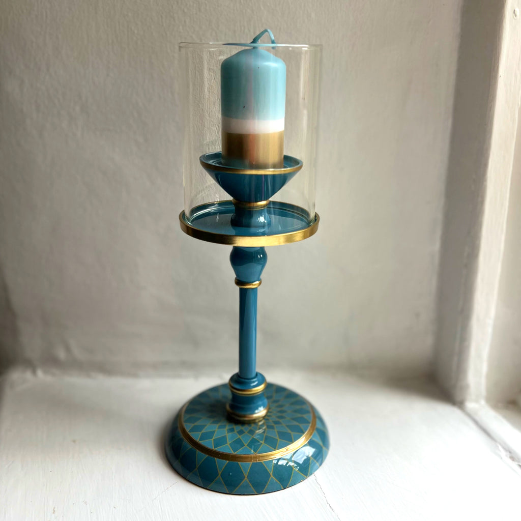 Harlequin hand-enamelled brass hurricane candle holder in Denim Blue with a blue pillar candle