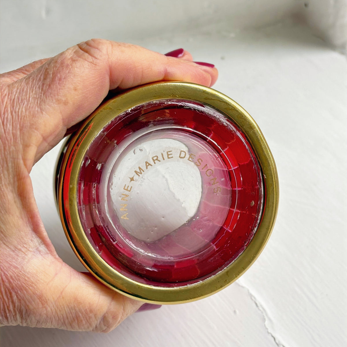 Strawberry Fizz striped glass tealight holder viewed from above in a hand