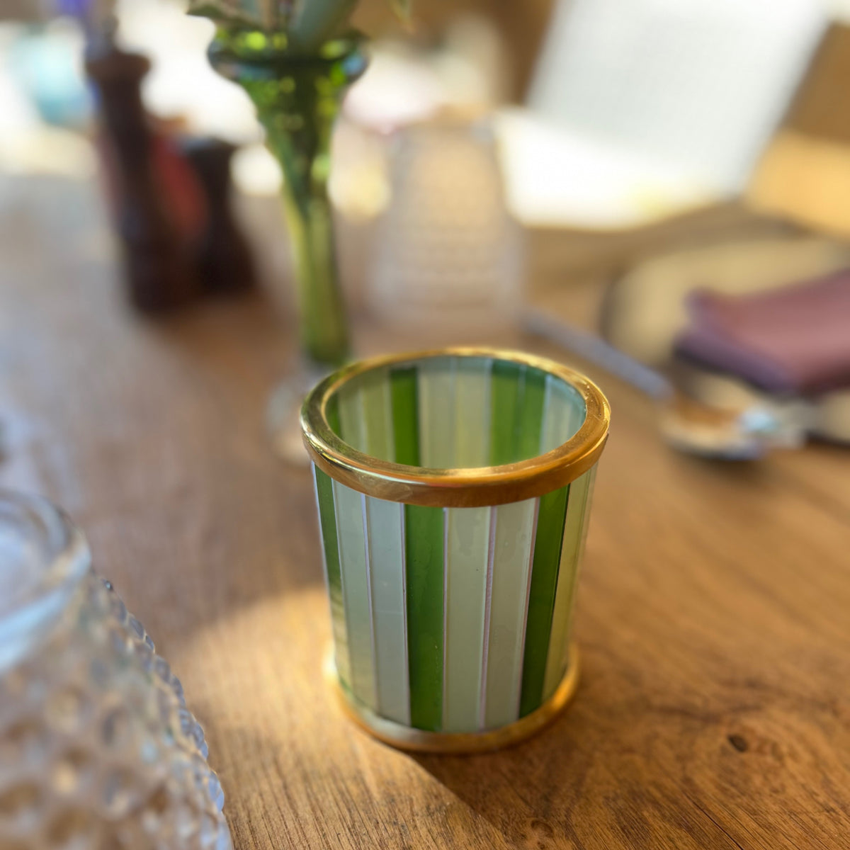 Handmade striped glass tealight holder in Garden Mint on a table