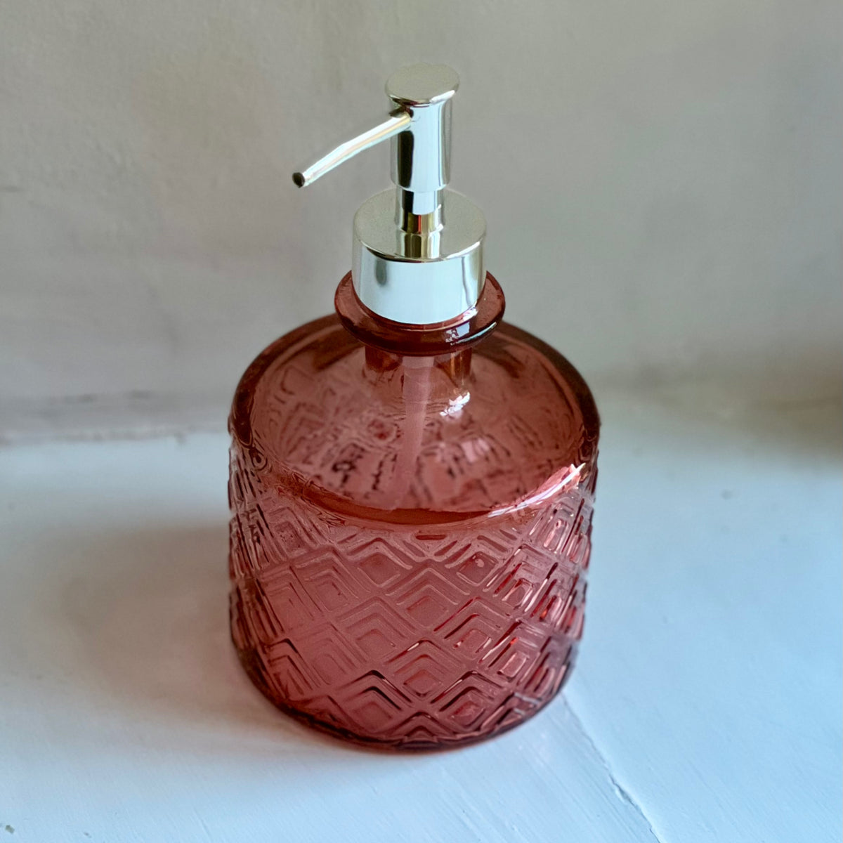 Pink textured recycled glass soap dispenser with a silver pump