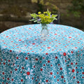 Round turquoise daisies tablecloth on a garden table with a vase of flowers