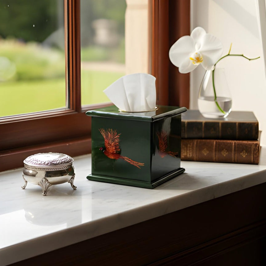 Pheasant square tissue box in bottle green enamel and brass on a desk by a window