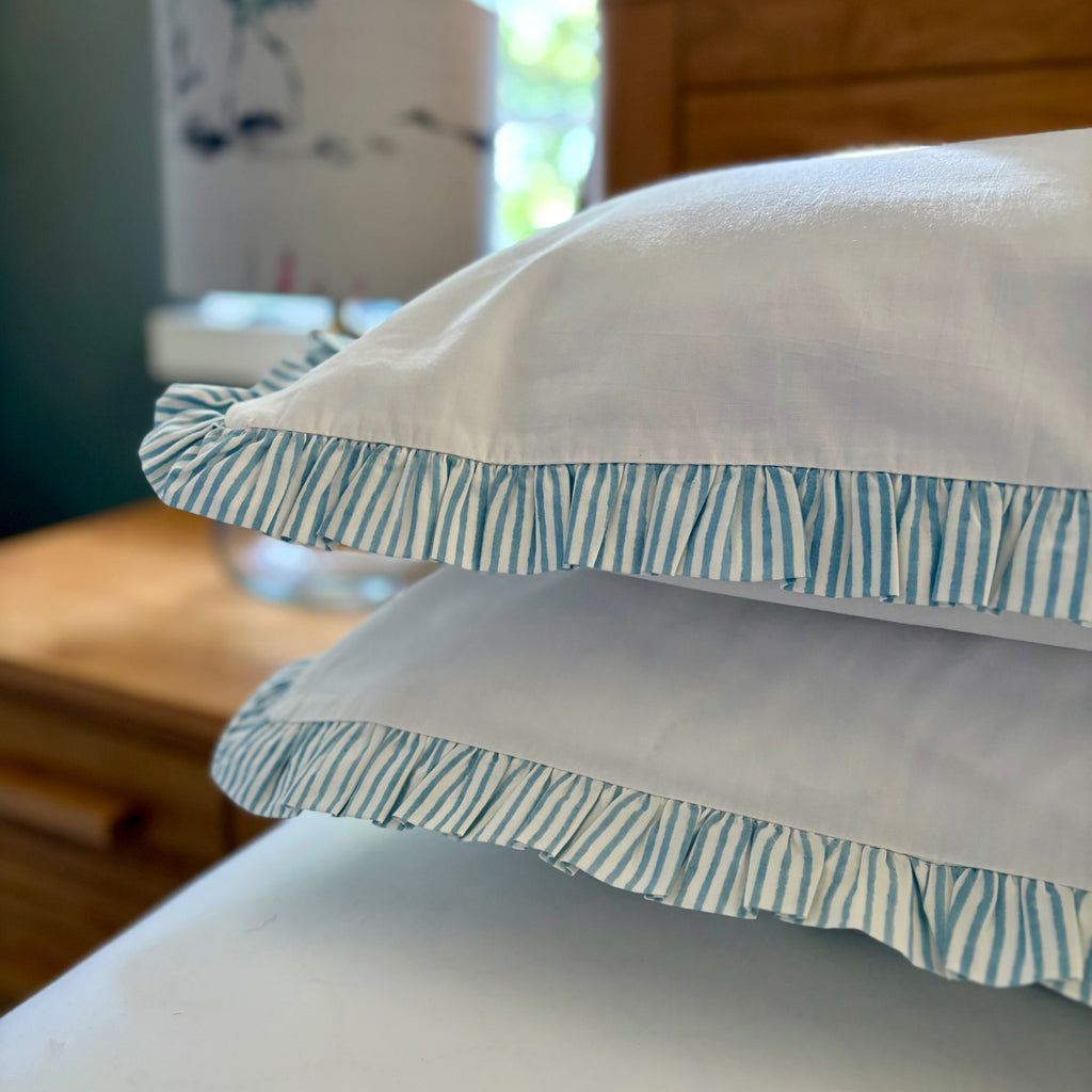Sea Breeze Blue Harlequin pillowcases with striped frills on the quilt