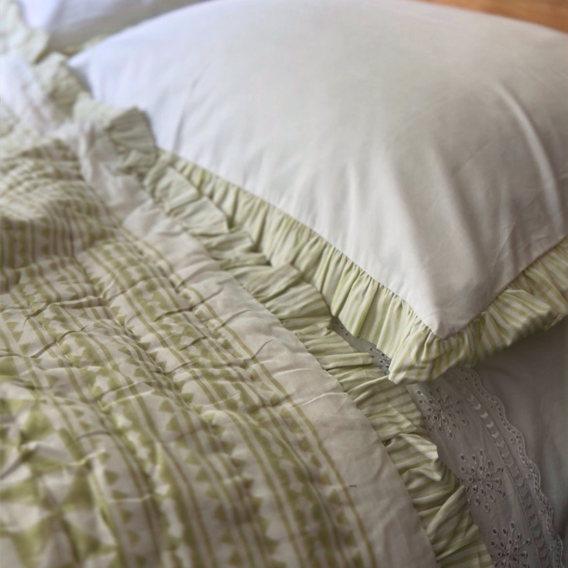 Apple Green Harlequin pillowcases on a quilted bed